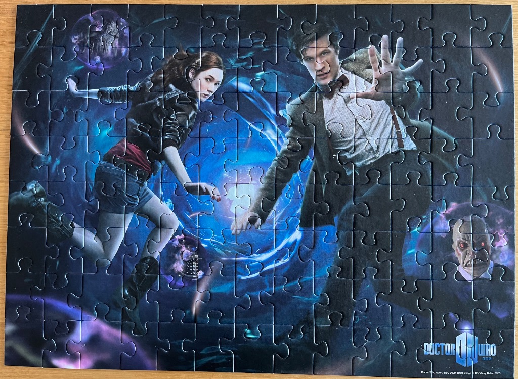 Doctor Who Eleventh Doctor and Amy Pond in front of a blue time vortex