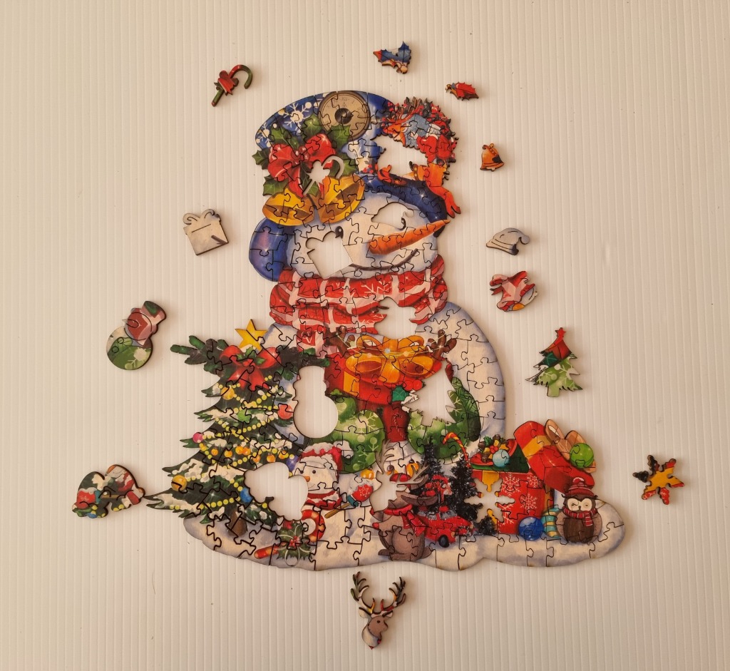 A whimsical illustration of a snowman decorated with holiday motifs against a plain background.