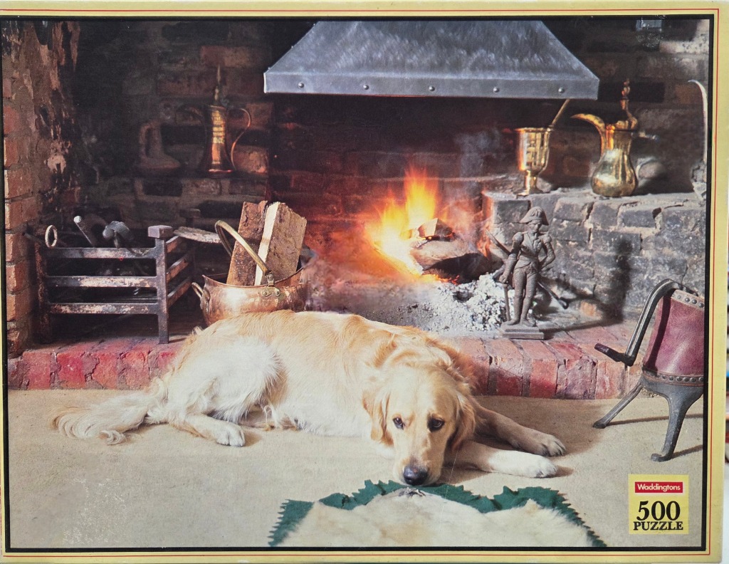 Golden retriever lying in front of a warm brick fireplace with various metal and decorative objects