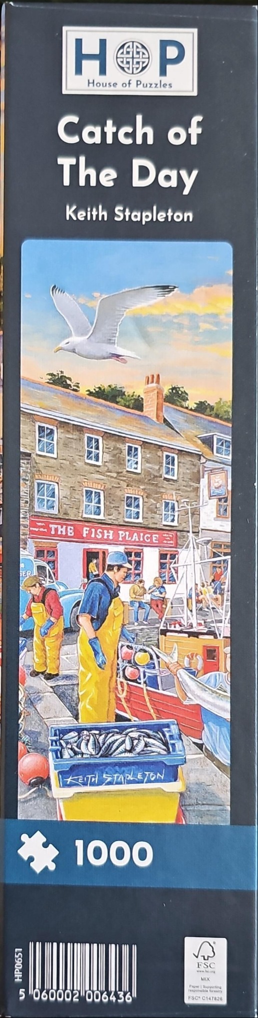 A busy harbor scene featuring fishermen in yellow oilskins unloading a catch of fish in front of a seaside building.