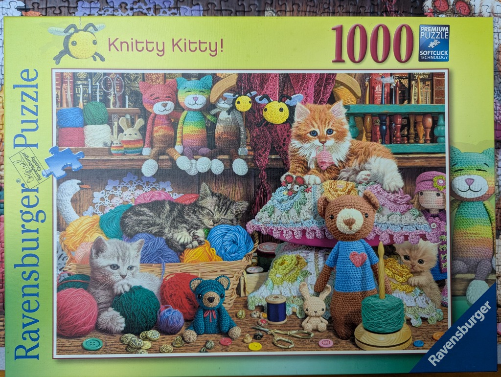 A cozy room filled with kittens and crocheted toys among yarn, needles, and knitting supplies.
