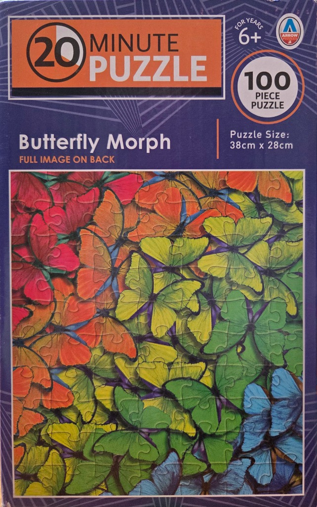 A dense, vibrant collage of butterflies in a gradient of colors from red and orange to green and blue.