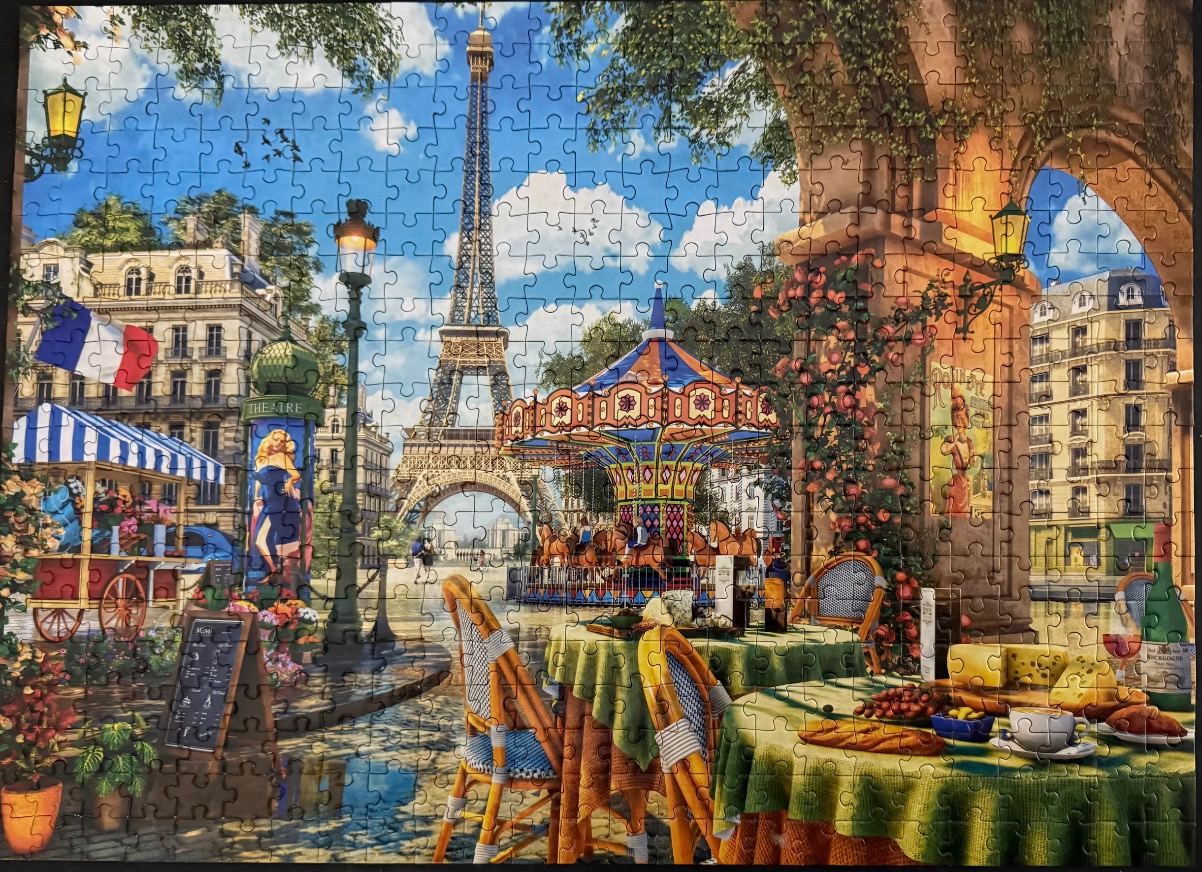 Parisian street scene with Eiffel Tower and carousel viewed from a cafe terrace.
