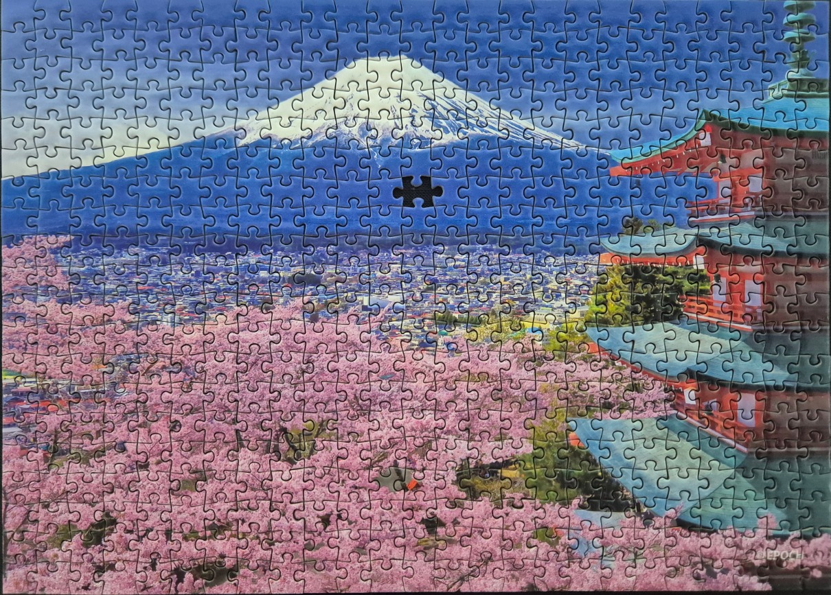 Mount Fuji rising behind a vibrant cherry blossom grove and a red pagoda
