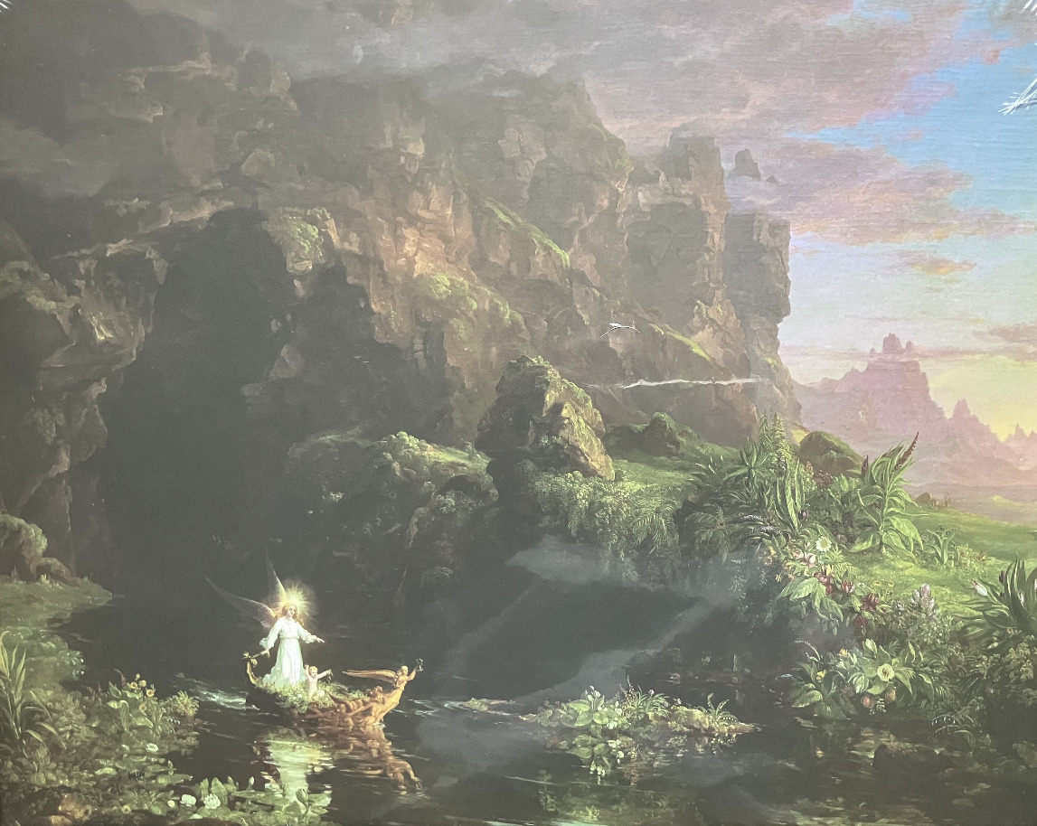 A glowing winged figure in a small boat navigates a dark, mystical river beneath towering, verdant cliffs.