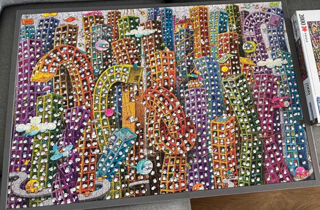 A dense, colorful illustration of a chaotic city filled with many small, white, anthropomorphic birds in every window.