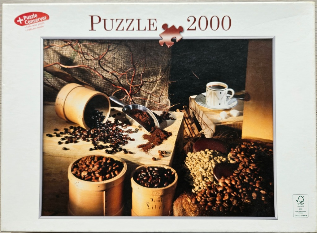 A still life featuring coffee beans, ground coffee, and a cup of coffee on rustic wooden surfaces.