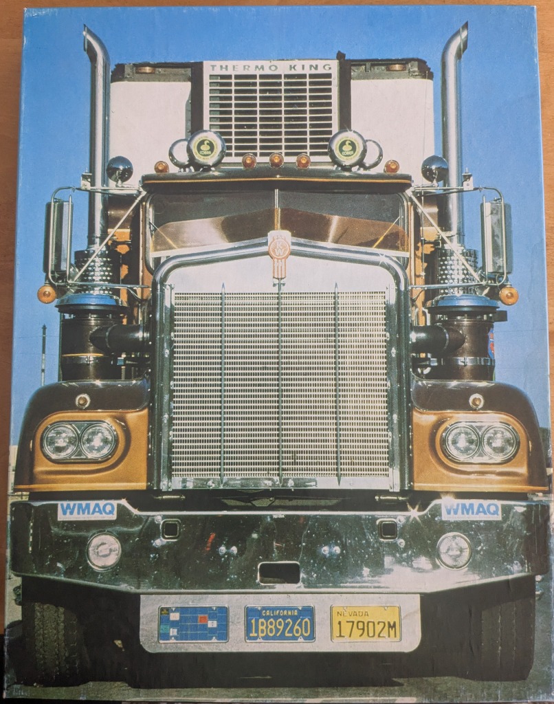 Front-facing view of a vintage Kenworth semi-truck against a clear blue sky.