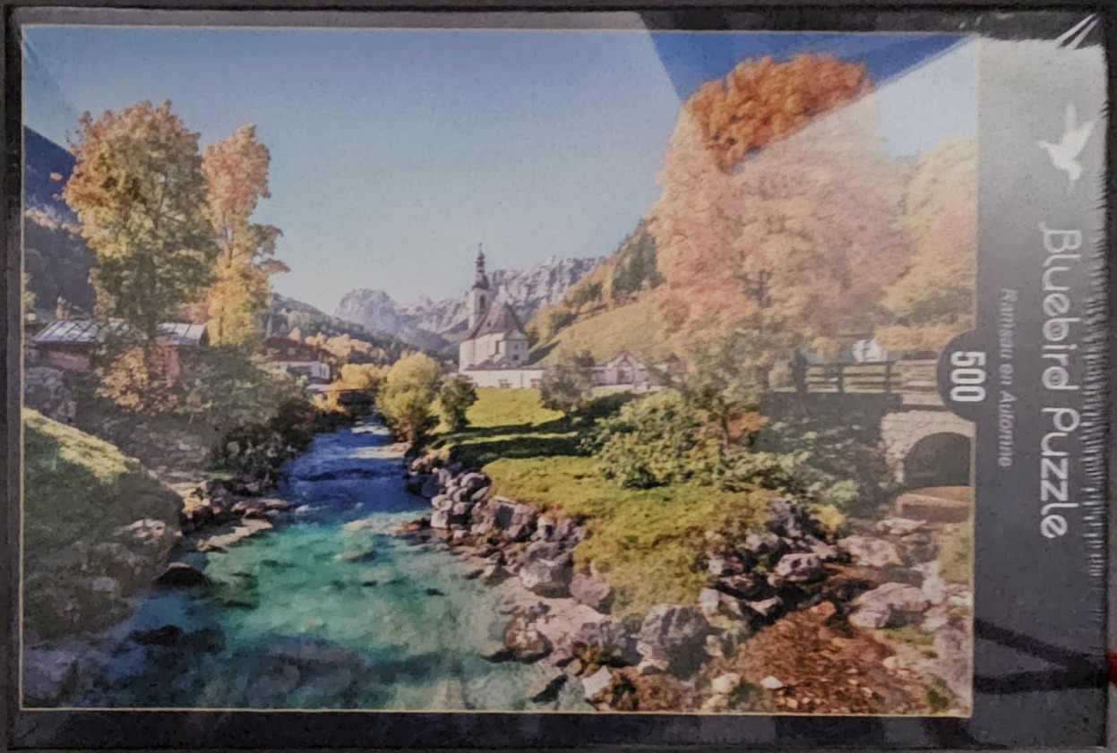 A peaceful autumnal landscape of Ramsau, Germany featuring a church by a river.