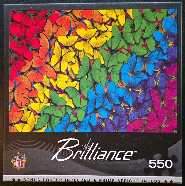 A dense, vibrant collage of butterflies arranged in a spectrum of rainbow colors.