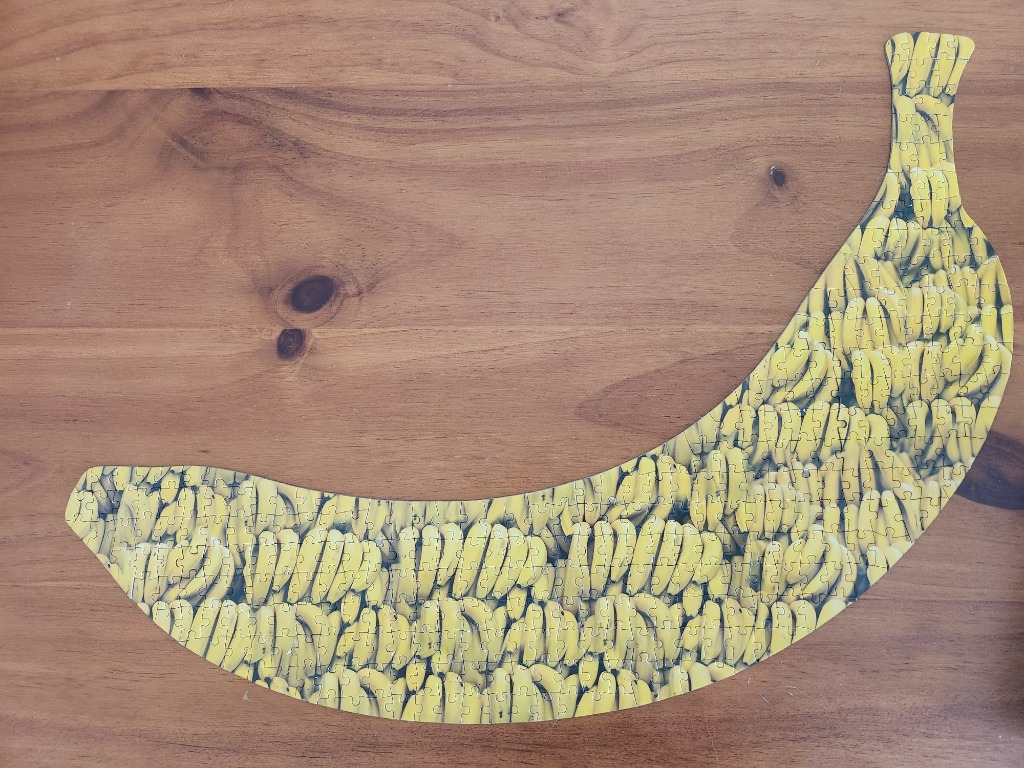 A crescent-shaped image filled with a dense, repeating pattern of ripe yellow bananas.