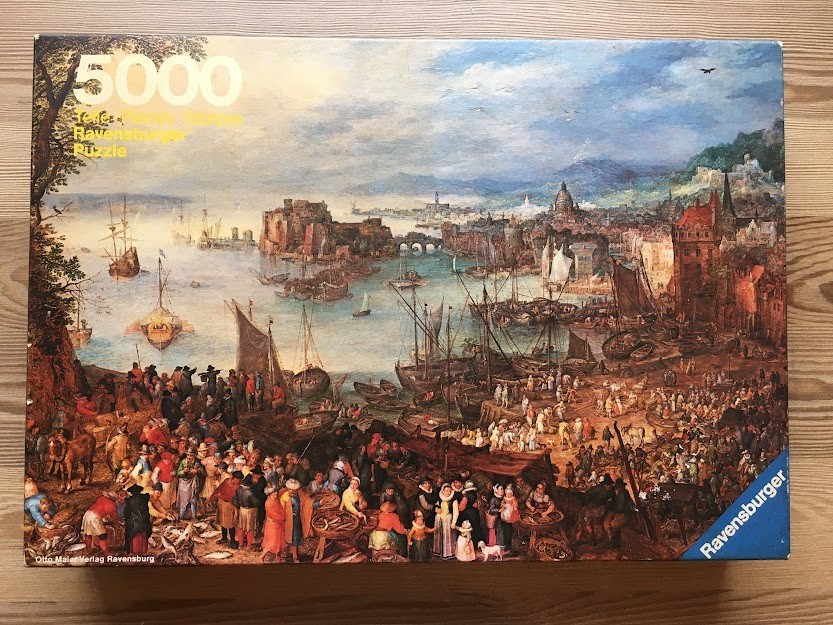 An oil painting of a busy, historical European harbor scene with numerous wooden ships, merchants, and a coastal city.