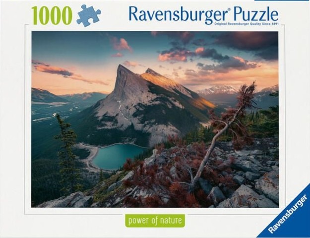 A scenic photograph of a jagged mountain peak rising above a turquoise lake at sunset.
