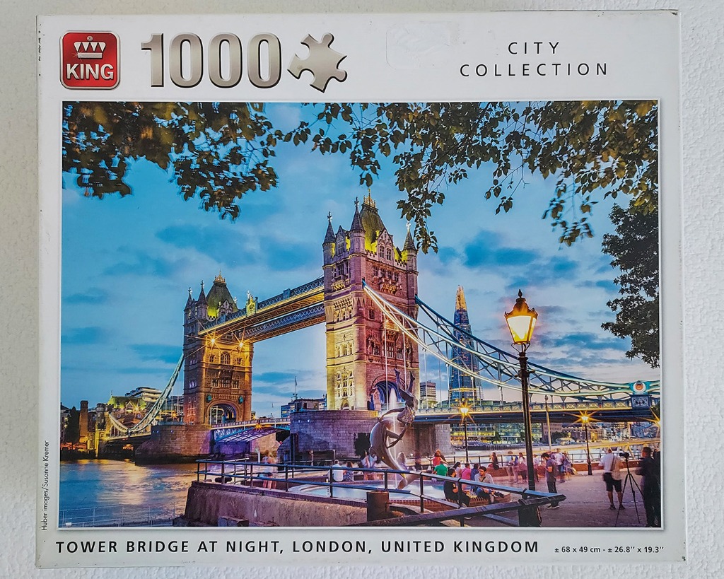 Tower Bridge in London at twilight with a riverside promenade and The Shard in the background.