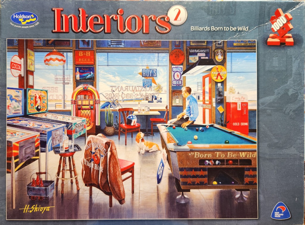 A nostalgic 1950s-style diner interior featuring pinball machines, a jukebox, and a man playing billiards.