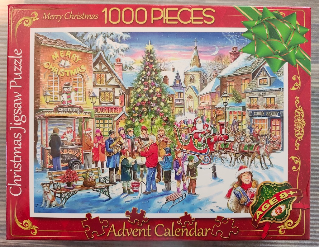 A cozy winter village scene featuring a Christmas tree, carolers, and Santa in a sleigh.