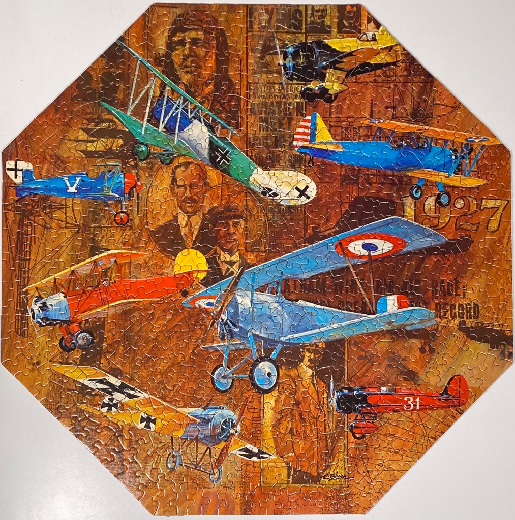 An octagonal collage featuring vintage airplanes layered over a sepia-toned background of historical aviation imagery.