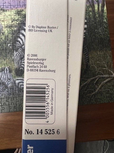 Zebras grazing in a lush green forest setting.