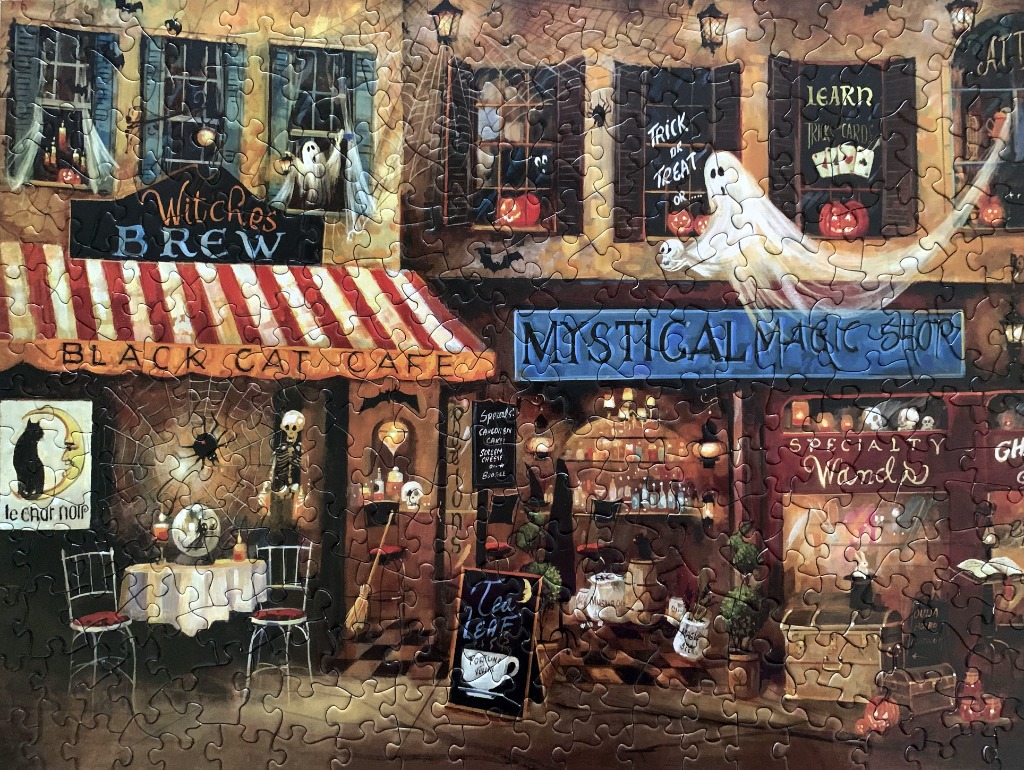 Illustration of a spooky Halloween-themed street scene with a cafe and a magic shop.