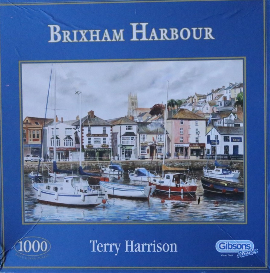 A watercolor painting of Brixham Harbour showing moored boats and colorful seaside buildings under a cloudy sky.