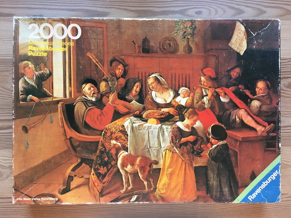 A 17th-century style interior scene featuring a festive, candlelit family gathering with food, music, and a dog.