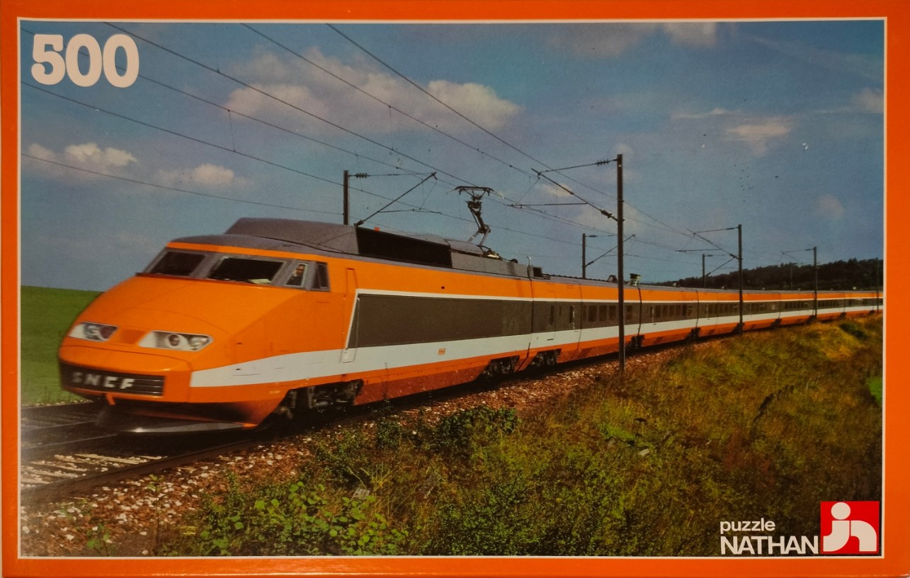 A bright orange and grey TGV high-speed train travels along tracks through a rural landscape.
