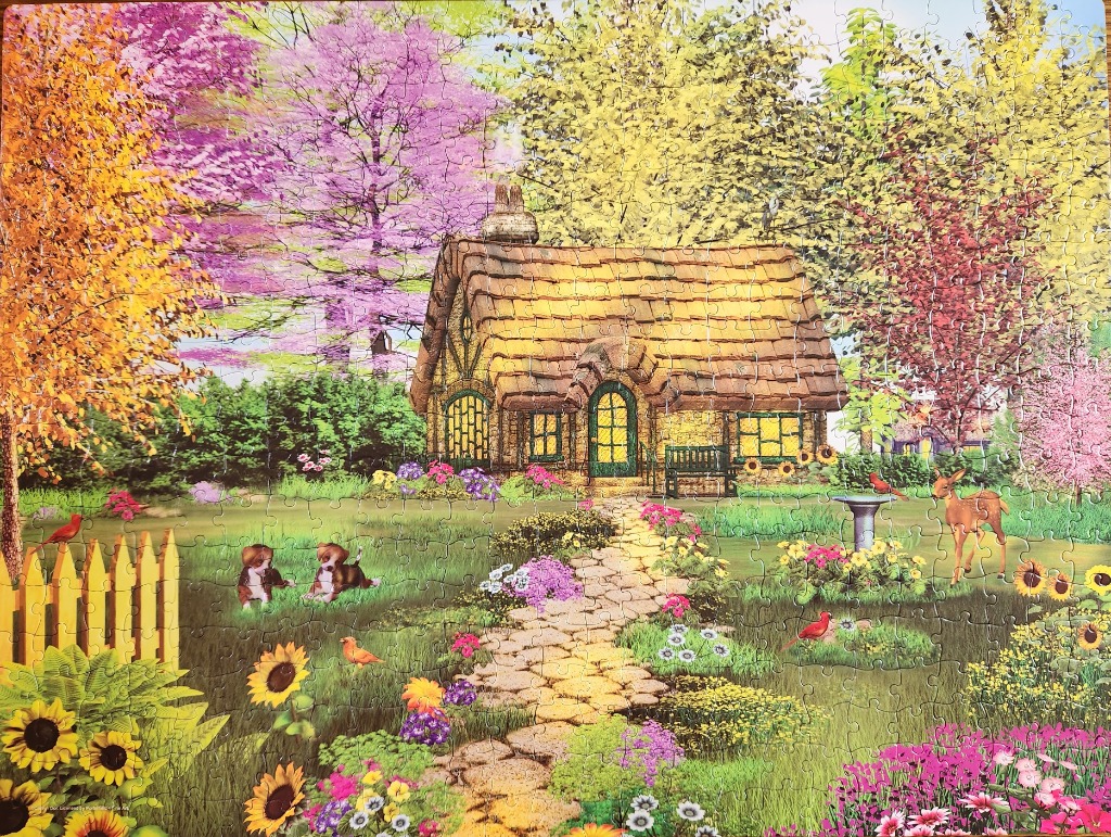 A thatched-roof cottage in a lush, floral garden with puppies and a deer