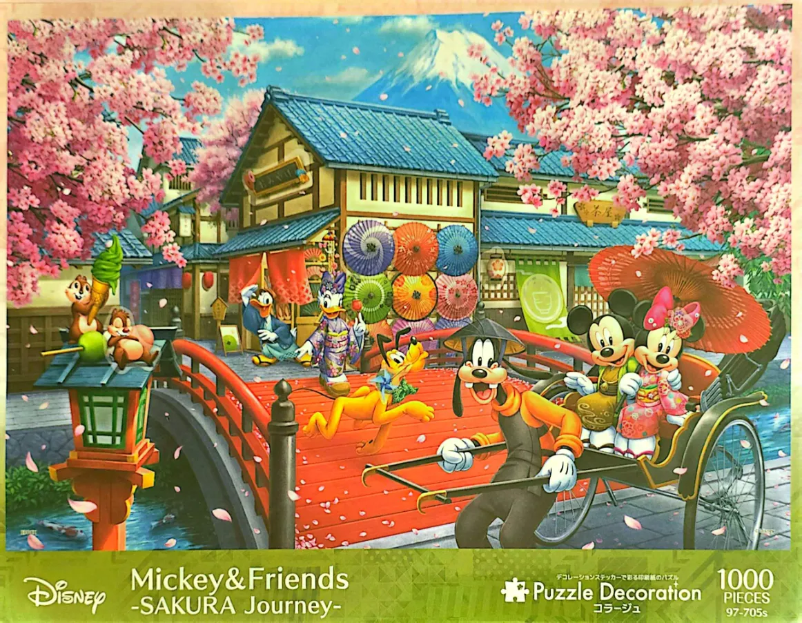 Mickey and friends in traditional Japanese clothing walking near a red bridge with Mt. Fuji in the background.