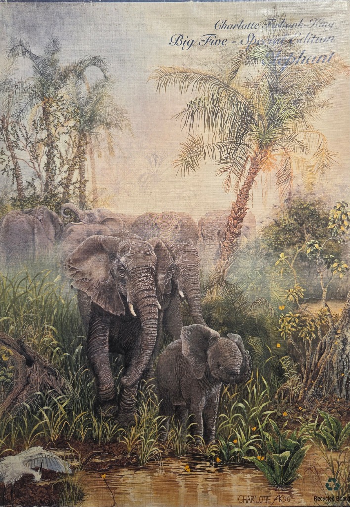 A herd of African elephants walking through a misty, tropical landscape with a calf in the foreground.