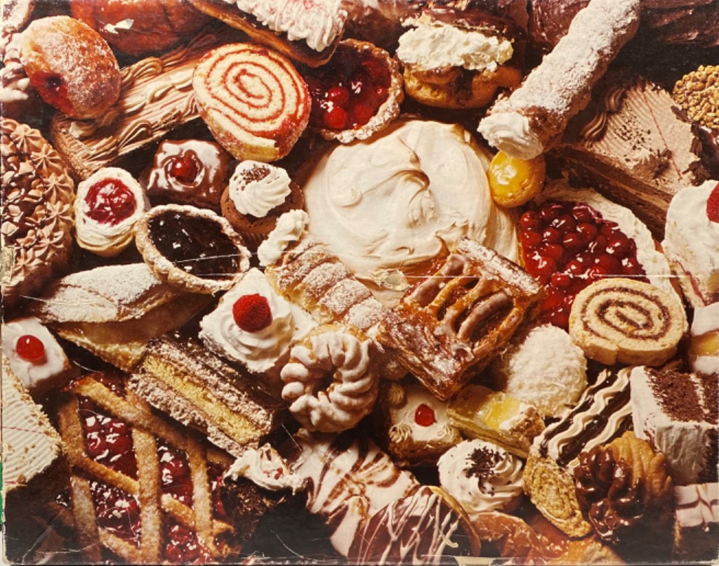 A dense, overhead collage of assorted pastries, cakes, and tarts