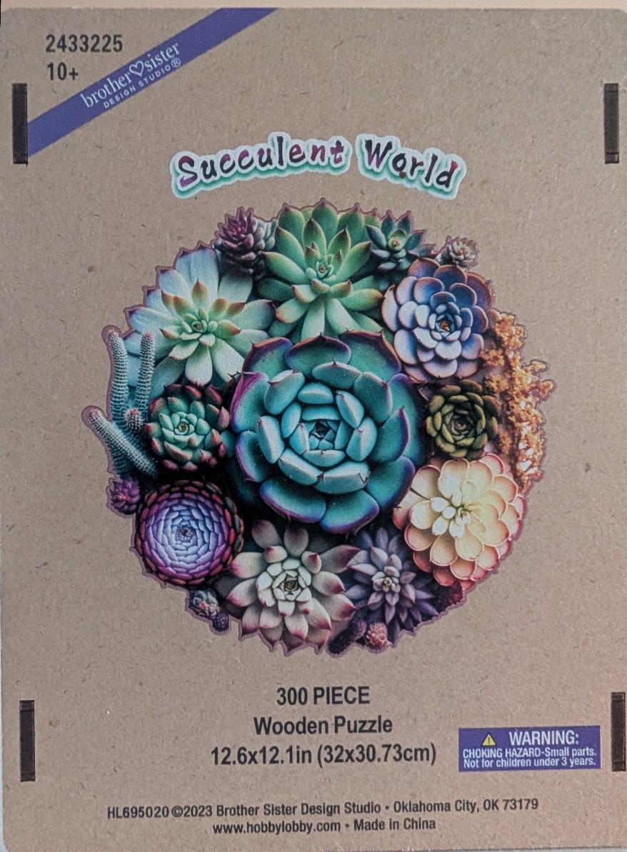 A collection of various succulents in a dense, circular arrangement against a plain tan background.