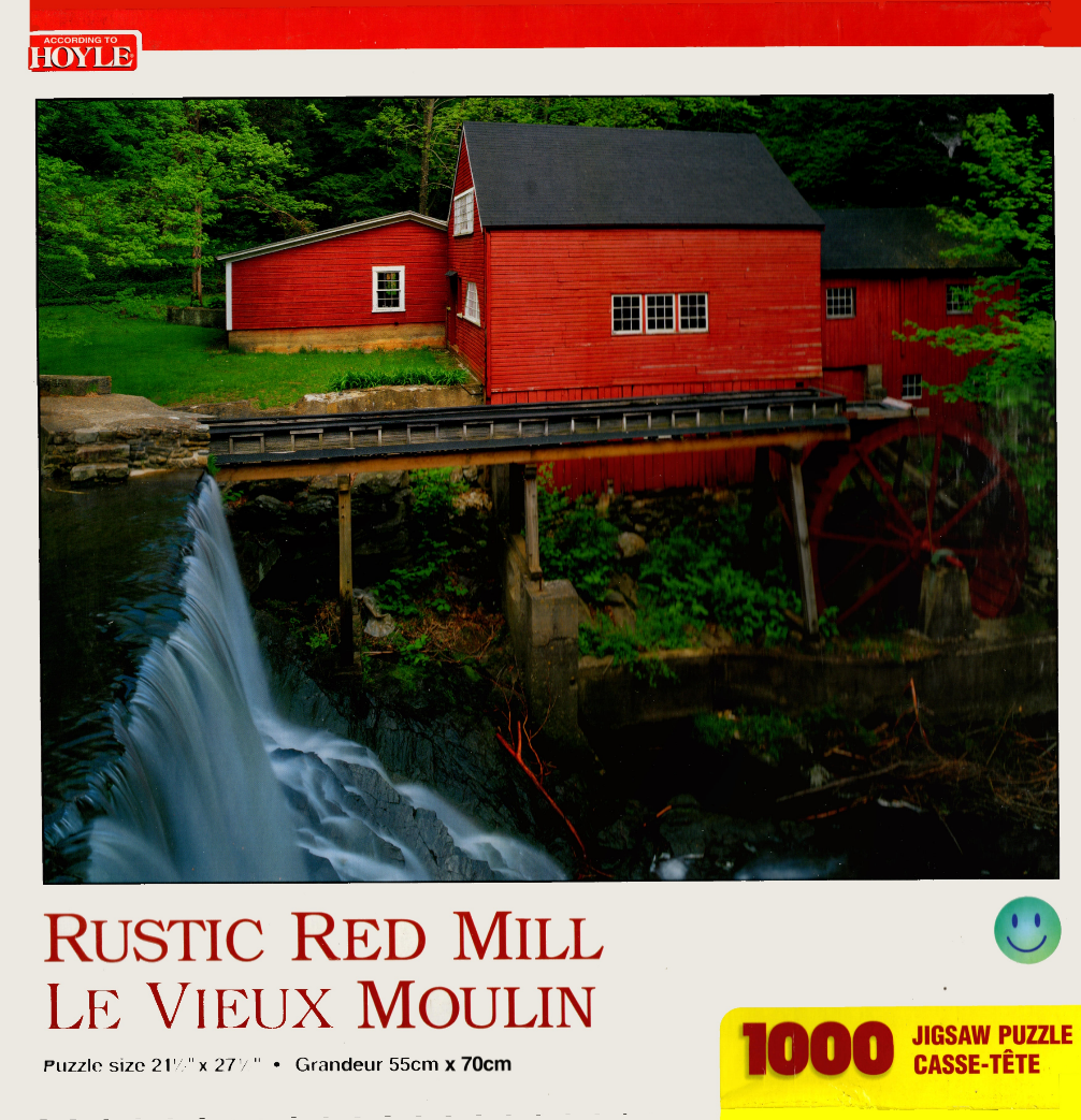 A vibrant red historic mill building sits beside a waterfall and lush green trees.