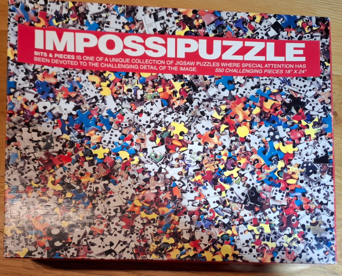 A chaotic, high-angle close-up of a multitude of scattered jigsaw puzzle pieces featuring varied colors and patterns.