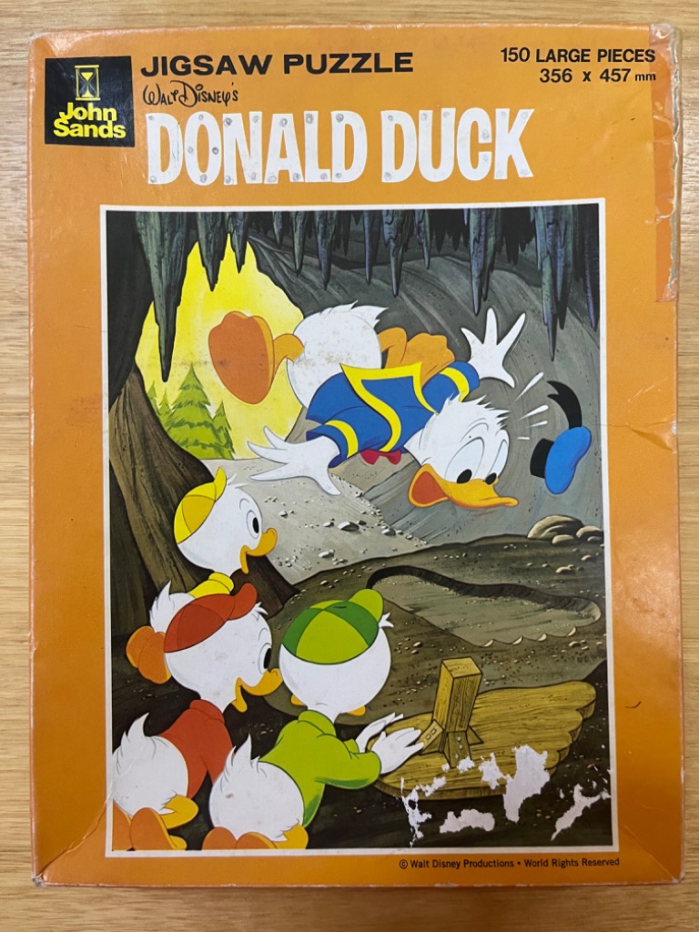 Donald Duck falling toward his three nephews, Huey, Dewey, and Louie, inside a dark cave.