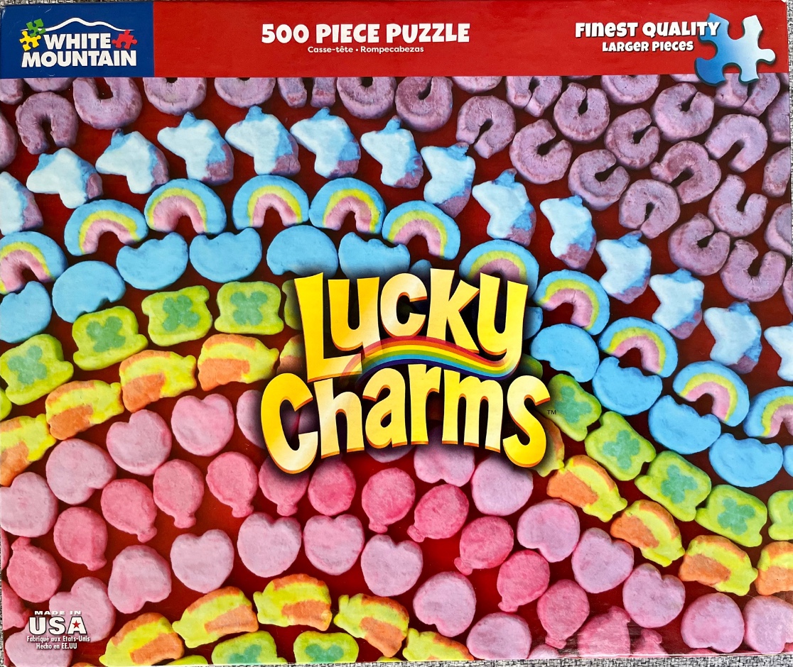 A close-up view of Lucky Charms marshmallows arranged in curved rows against a bright red background.