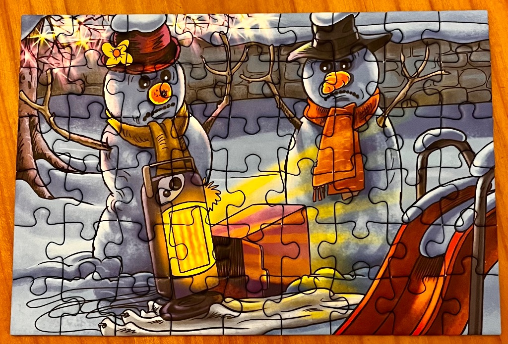 Two grumpy snowmen with orange scarves stand by a lit lantern and sled.