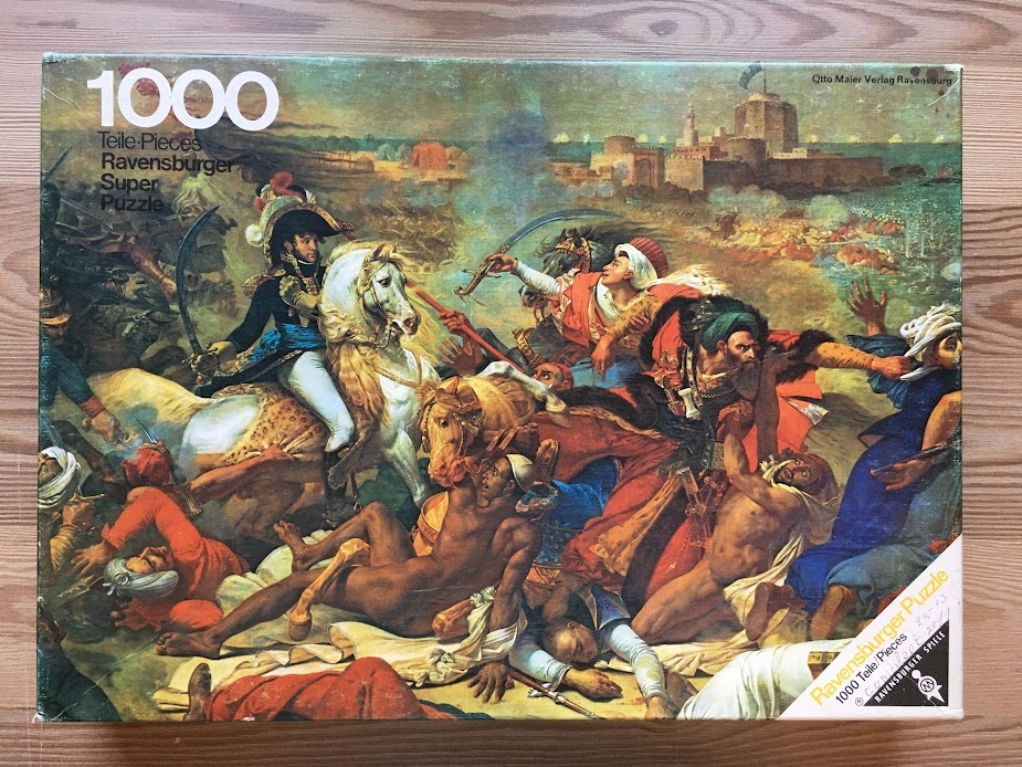 An oil painting depicts a chaotic 18th-century battle scene with Napoleon Bonaparte on a white horse amidst intense combat.