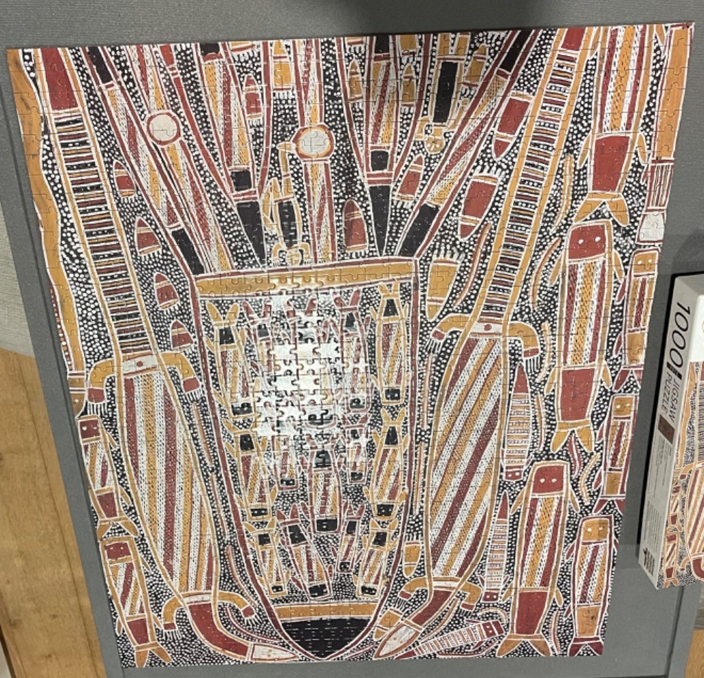 Indigenous Australian style dot painting featuring stylized fish and geometric patterns in earth tones