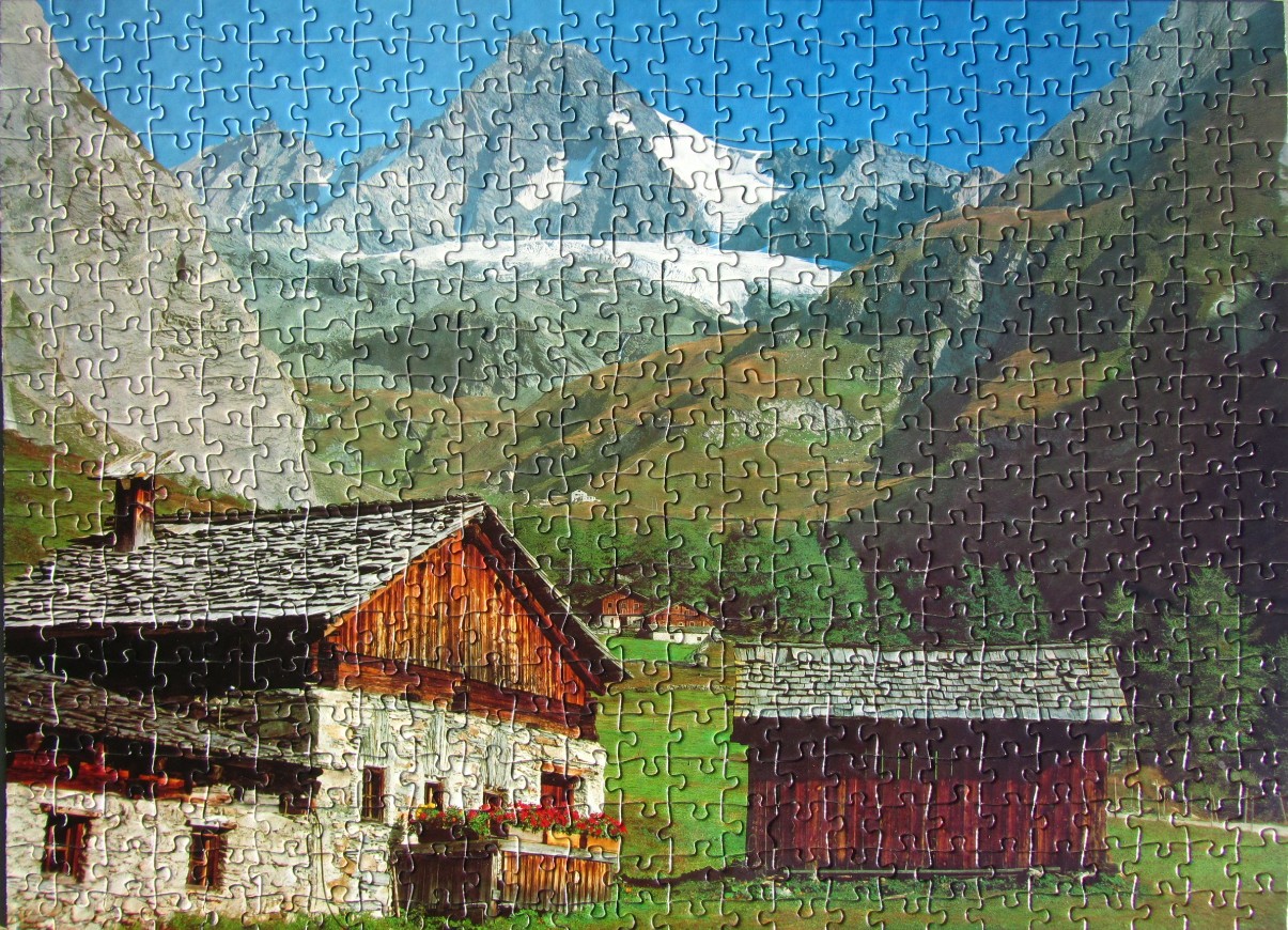 A sunny mountain scene featuring a rustic alpine farmhouse, a wooden barn, and a snow-capped mountain peak in the back.