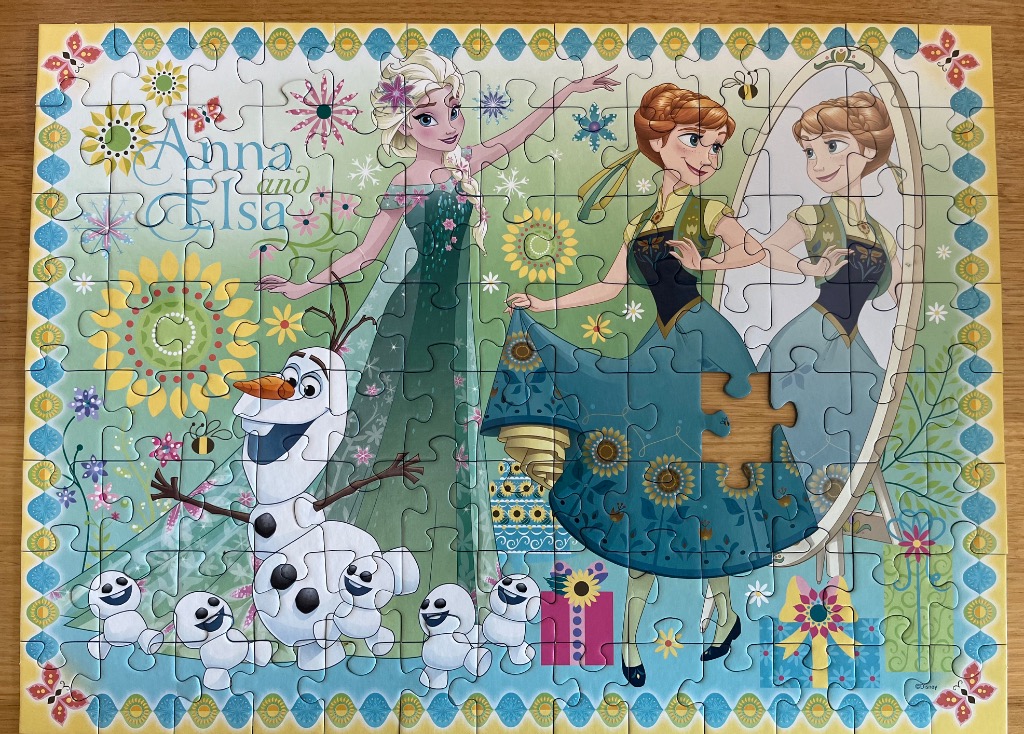 Illustration of Elsa, Anna, and Olaf from Frozen surrounded by sunflowers and spring motifs.