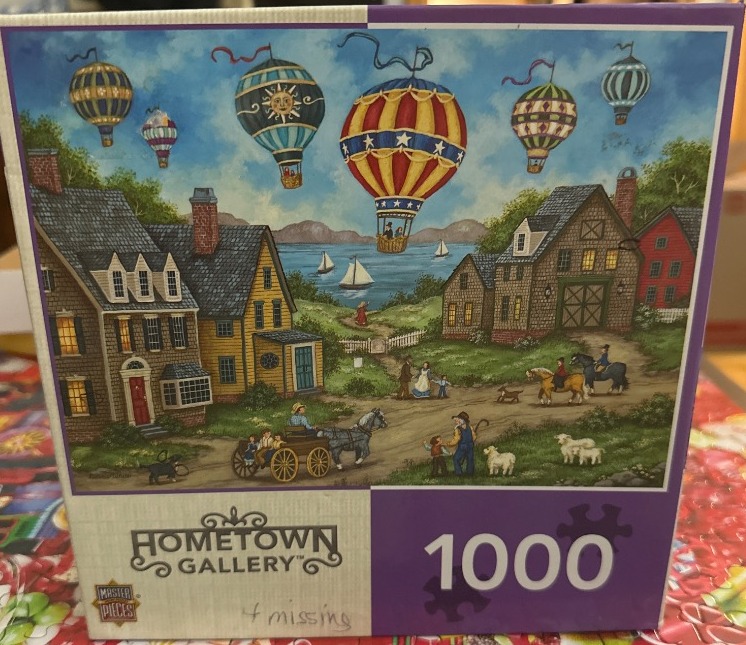 An illustration of a rural village scene with several hot air balloons floating over a bay.