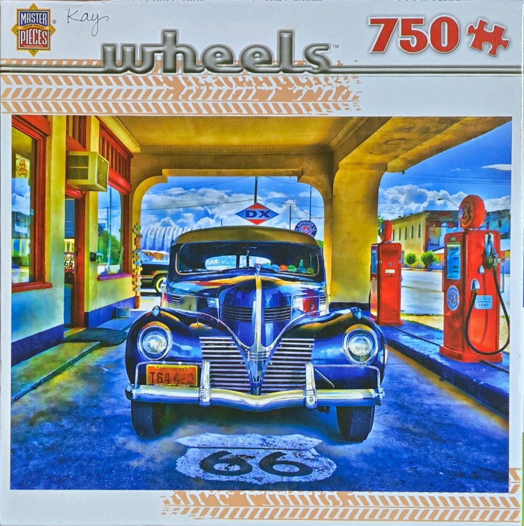 A vintage blue car parked at a retro gas station under a covered awning.