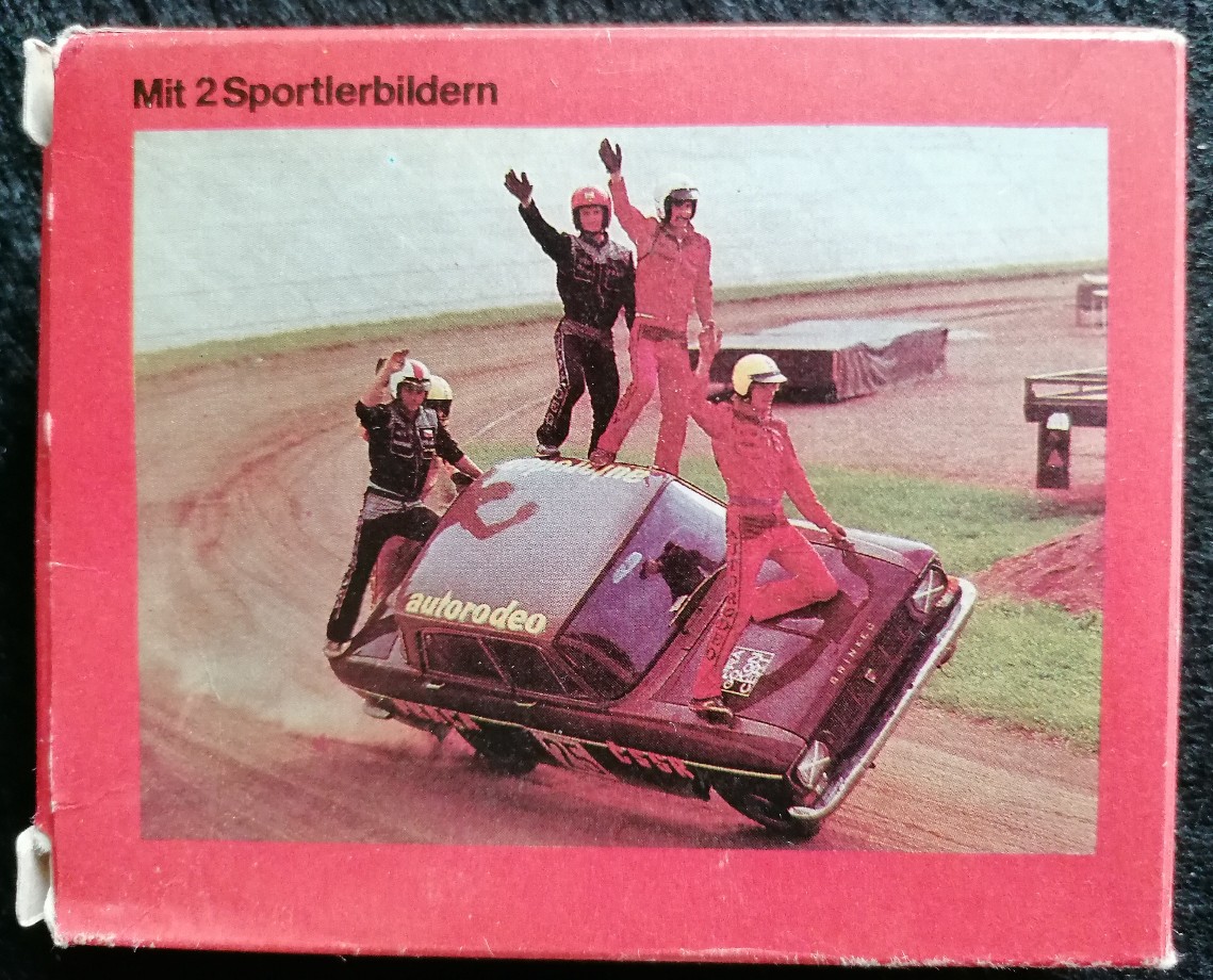 Stunt performers standing on a moving car at a dirt track