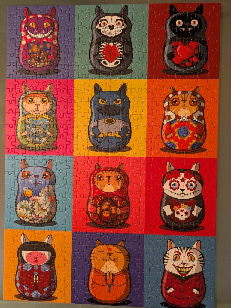 A grid of twelve stylized cat-themed Matryoshka nesting dolls in various colorful costumes.