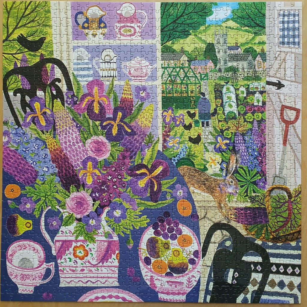 An illustration of a lush garden viewed through a window, with a table in the foreground holding flowers and fruit.