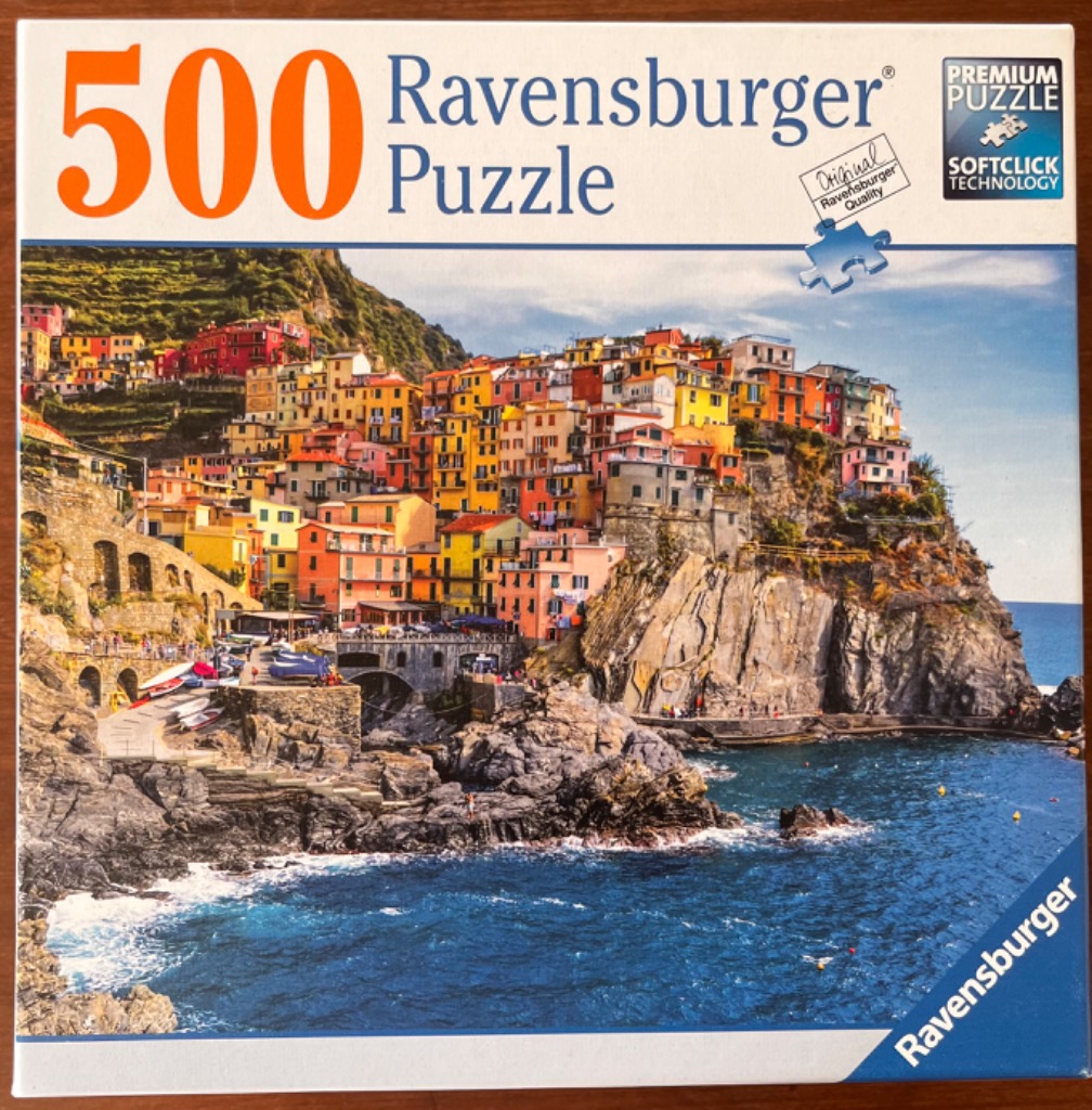A coastal town in Italy with vibrant buildings perched on steep cliffs above a blue sea.