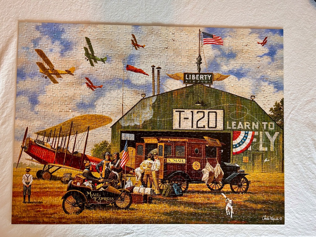 Vintage illustration of an early 20th-century airfield with biplanes and a mail delivery truck.
