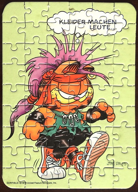 Cartoon illustration of Garfield dressed in punk rock attire against a light green background.