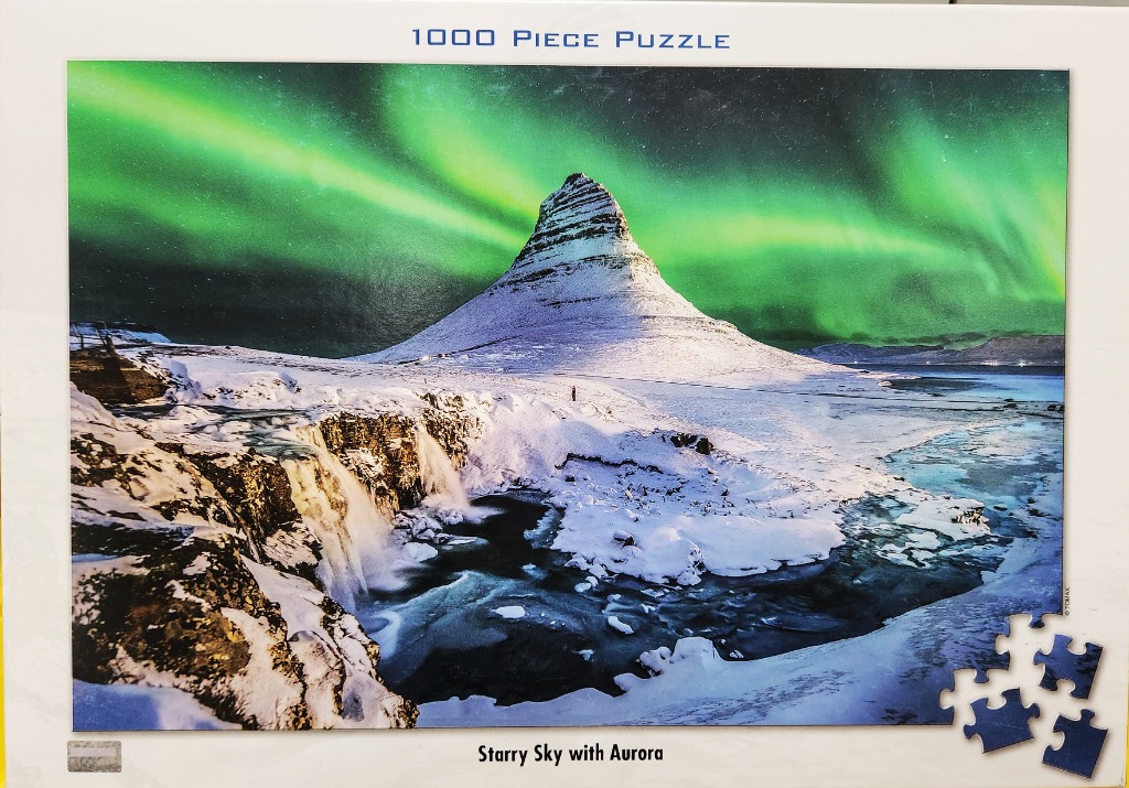 Kirkjufell mountain in Iceland under a vibrant green aurora borealis at night