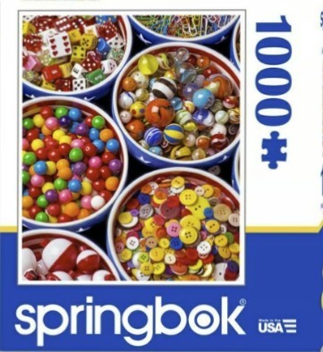Close-up of five bowls filled with colorful dice, marbles, gumballs, buttons, and fishing bobbers.
